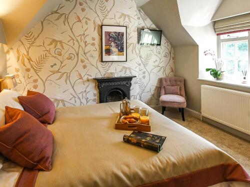 Brantingham的住宿－Pond View Cottage，一间卧室,配有一张床,上面放着橙子托盘