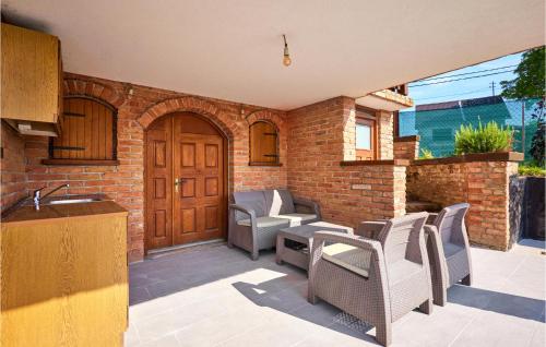 patio con sillas de mimbre y puerta de madera en Stunning Home In Klostar Ivanic With Sauna en Kloštar Ivanić