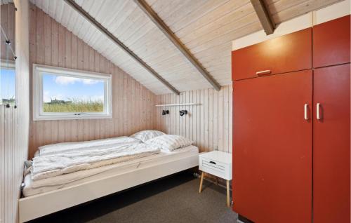 a small bedroom with a bed and a window at 3 Bedroom Stunning Home In Ringkbing in Søndervig