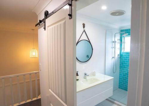 a bathroom with a sink and a shower and a mirror at Fantastic central location in Noosaville