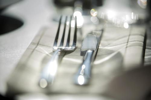 a group of silver forks sitting on a table at First Hotel Dragonen in Umeå
