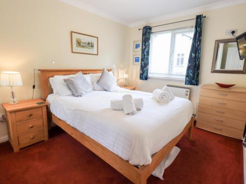 una camera da letto con un grande letto bianco con asciugamani di Fairview a Bowness-on-Windermere