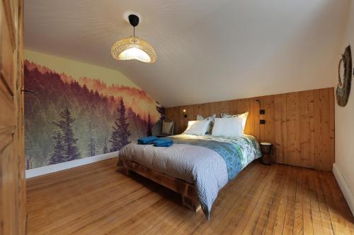 una camera da letto con un letto e un dipinto sul muro di Granit'Home a Gérardmer