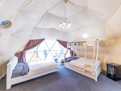 a bedroom with two beds in a tent at グランピング　星が見の杜 in Nakatsugawa