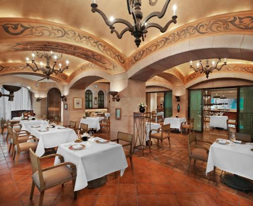 a restaurant with white tables and chairs and a ceiling at The St. Regis Beijing in Beijing