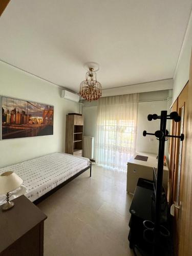 a bedroom with a bed and a chandelier at P & P Apartment in Alexandroupoli