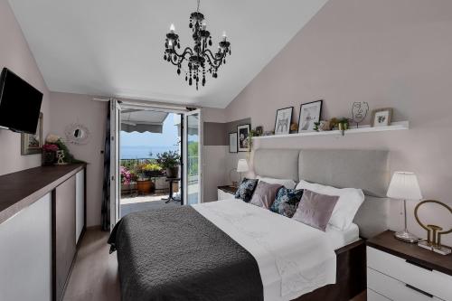 een slaapkamer met een groot bed en een kroonluchter bij Apartment Mucrum in Makarska