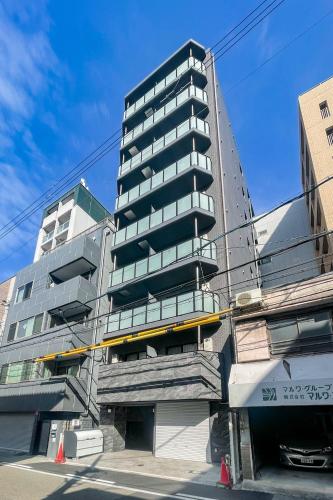 a tall apartment building with a staircase in front of it at Grandia Shinsaibashi in Osaka