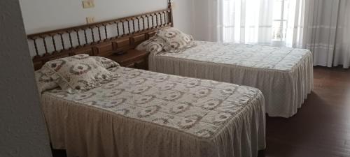 2 camas individuales en una habitación con falda en PENSION RESTAURANTE CASANOVA, en Puebla de Trives