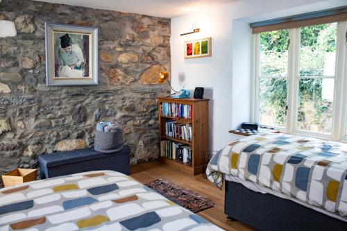 a bedroom with two beds and a stone wall at Minafon in Newport