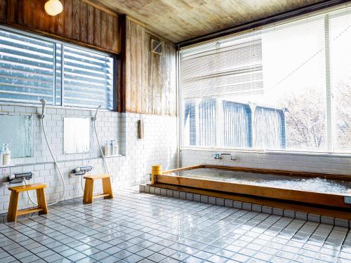 łazienka z wanną i dużym oknem w obiekcie グランピング　星が見の杜 w mieście Nakatsugawa