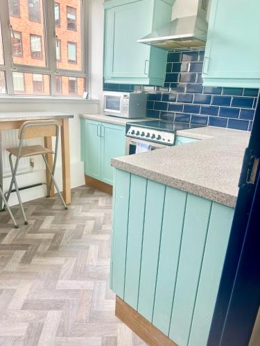 a kitchen with blue cabinets and a counter top at Small One bedroom flat near Covent garden in London
