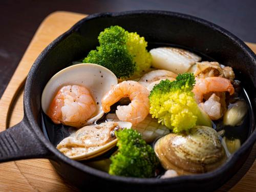 a pan filled with shrimp and vegetables on a table at グランピング　星が見の杜 in Nakatsugawa