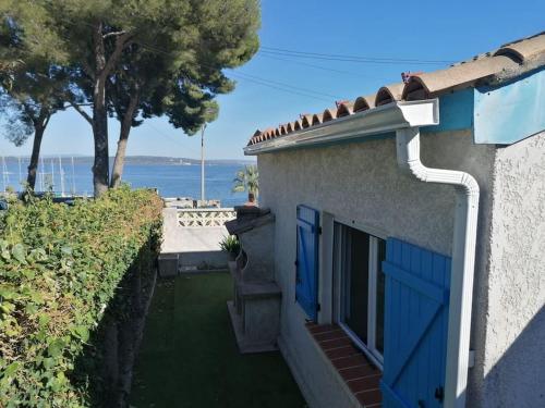 Cette maison dispose de portes bleues et offre une vue sur l'océan. dans l'établissement Maison T3 avec vue au bord de l’étang, à Istres