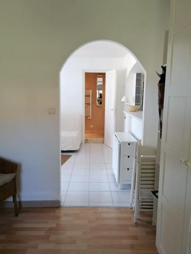 a hallway with an archway in a room with a kitchen at Maison T3 avec vue au bord de l’étang in Istres