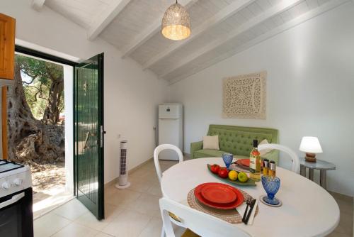 uma cozinha e sala de jantar com uma mesa branca e cadeiras em Aphrodite's hidden gem on Paxos island em Velianitátika