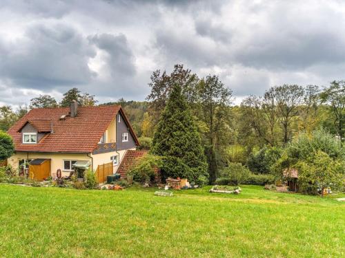 a house in a field with a green yard at Cozy Apartment in Marktrodach with Sauna in Kronach