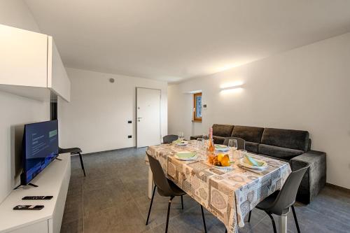 sala de estar con mesa y sofá en Appartamento Borgo Pastoedo - Happy Rentals en Tenno