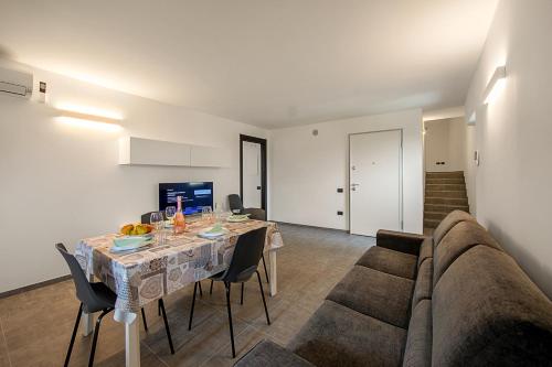 sala de estar con mesa y sofá en Appartamento Borgo Pastoedo - Happy Rentals en Tenno