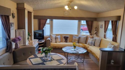 a living room with a couch and a tv at STATIC CARAVAN N WALES LyonsRobinHood RHYL in Meliden