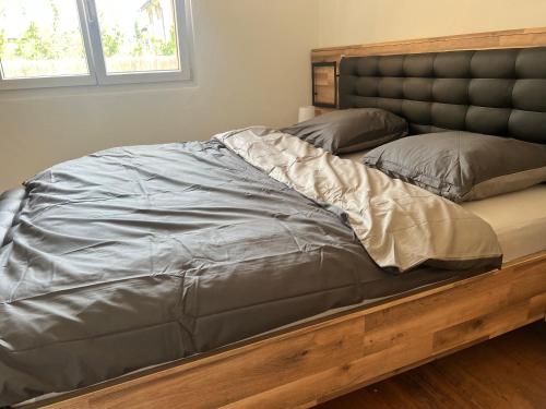 - un grand lit dans une chambre avec un cadre en bois dans l'établissement La Palmeraie, à Fully