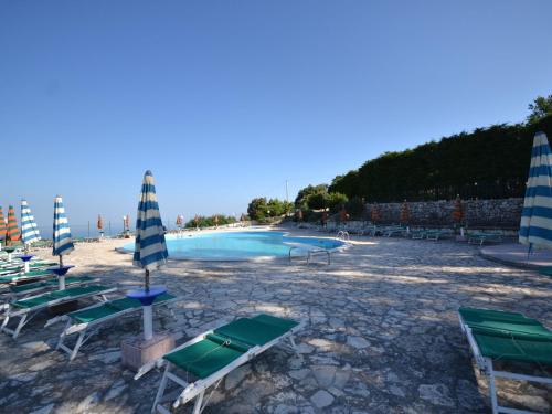 a swimming pool with lounge chairs and umbrellas at Holiday Home in Mattinata with Pool Tennis Court Bikes in Mattinata