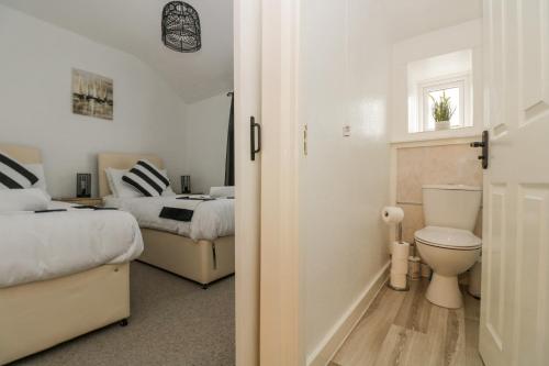 a bedroom with two beds and a toilet in it at Walter in Penzance