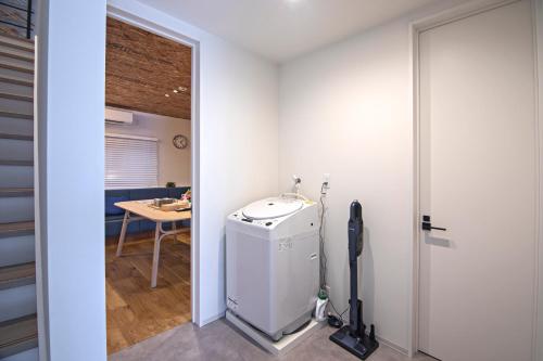大阪市にある新OPEN一棟貸切！西九条駅徒歩5分＊USJ直通＊グループ旅行最適＊トイレ2洗面台2の小型冷蔵庫、テーブルが備わる客室です。
