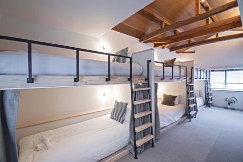 a room with two bunk beds and a staircase at 新OPEN一棟貸切！西九条駅徒歩5分＊USJ直通＊グループ旅行最適＊トイレ2洗面台2 in Osaka