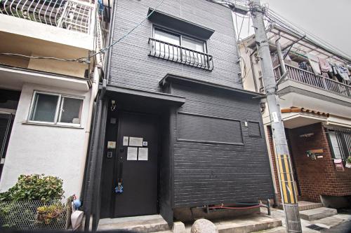 大阪市にある新OPEN一棟貸切！西九条駅徒歩5分＊USJ直通＊グループ旅行最適＊トイレ2洗面台2の黒い扉のある黒い家