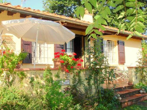una casa con un paraguas delante en Surrounded by the beautiful sloping Tuscan landscape, en Casole dʼElsa
