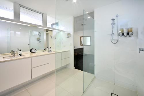 a white bathroom with a shower and a sink at Elegant, Stylish, Magical Coolum Beach House - ZA8 in Coolum Beach
