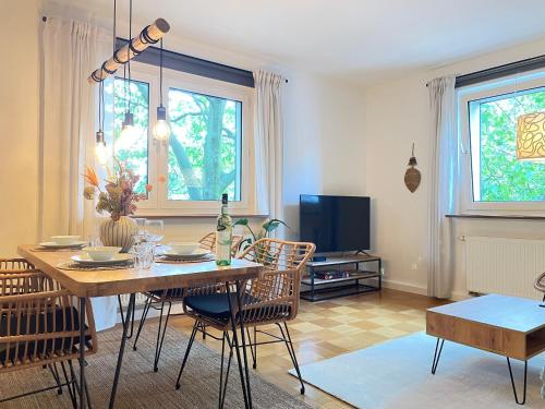 a living room with a table and chairs and a television at Boho Style Apartment - Messe - Rüttenscheid in Essen