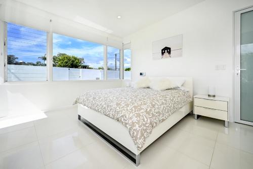 a white bedroom with a bed and a window at Elegant, Stylish, Magical Coolum Beach House - ZA8 in Coolum Beach