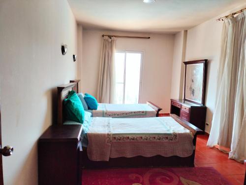 a bedroom with two beds and a window at جولف بورتو مارينا in El Alamein