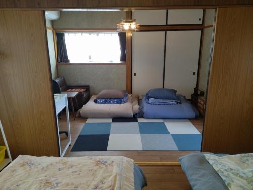 民家の一室2 Private Room in Japanese Vintage House with 2 Beds, Free Parking Good to Travel for Tashiro Cats Islandにあるベッド