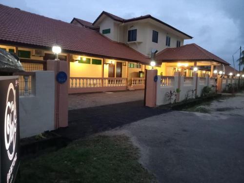a house with a fence with lights on it at Blackstone Beach Resort in Kuantan