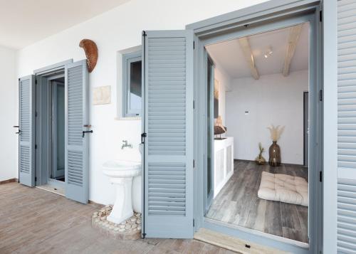 a bathroom with blue doors and a toilet at Claro De Lua Circeo B&B in San Felice Circeo