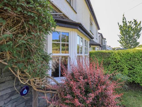 a house with a window and some bushes at Timley Knott in Coniston