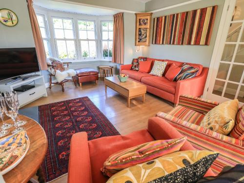 a living room with red couches and a table at Timley Knott in Coniston