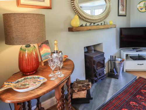 a room with a table with a lamp and a wood stove at Timley Knott in Coniston