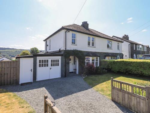 a white house with a garage and a fence at Timley Knott in Coniston