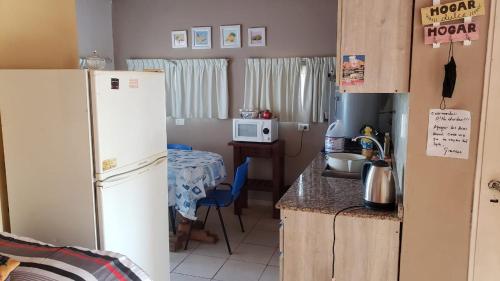 a kitchen with a white refrigerator and a table at Complejo Las chacras in Juana Koslay 