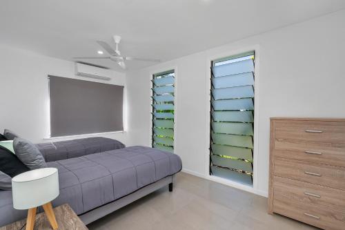 a bedroom with a purple bed and green shelves at Endeavour Holiday House Clifton Beach in Clifton Beach