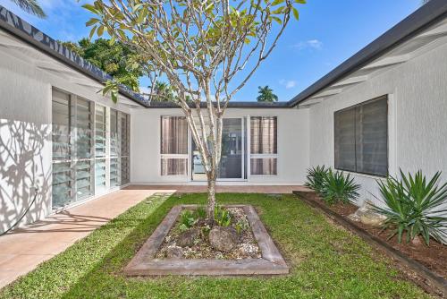 a home with a tree in the front yard at Endeavour Holiday House Clifton Beach in Clifton Beach
