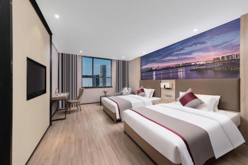 two beds in a hotel room with a large painting on the wall at Morninginn, Meixi Lake West Bus Station in Changsha