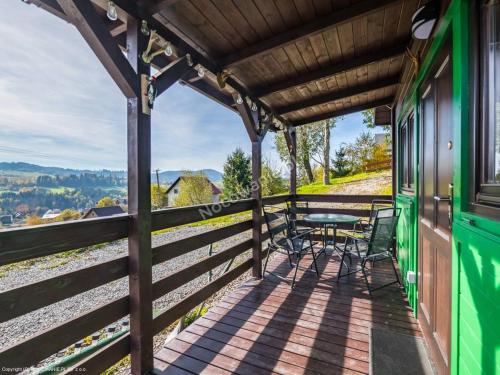 einen Balkon eines Zuges mit einem Tisch und Stühlen in der Unterkunft Domek Pod Groniem in Jasnowice