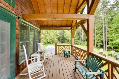 a wooden porch with rocking chairs on it at Secluded Elka Park Cabin Hot Tub and Fire Pit! in Elka Park