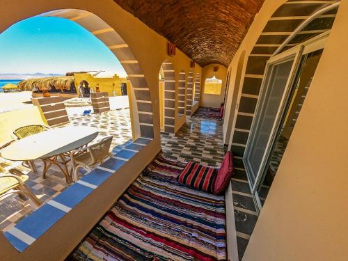 a balcony with a table and chairs and a rug at Flight Mode Camp in Nuweiba