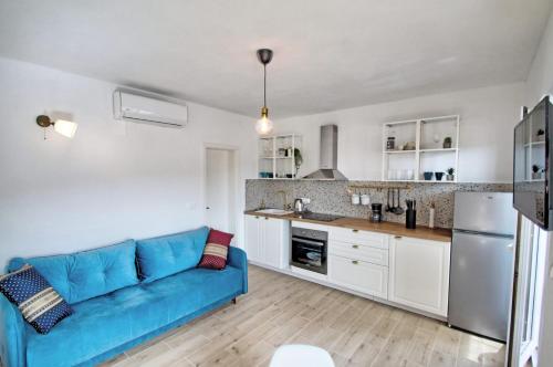 a living room with a blue couch in a kitchen at Apartments Kondrić in Vinjerac